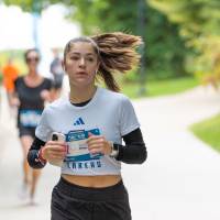 Participant in white shirt running through campus